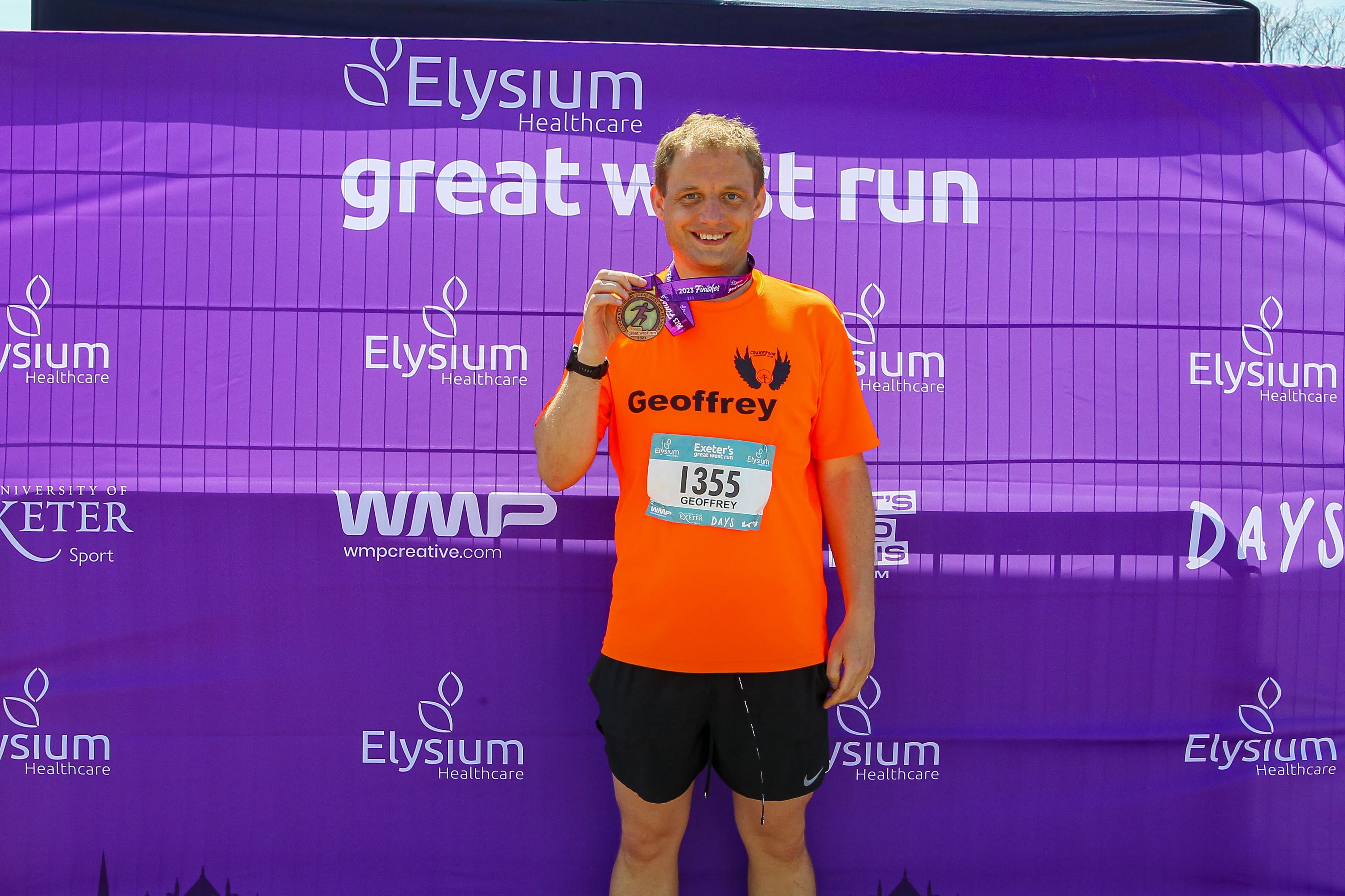 Geoffrey Hayward holding his finishers medal.